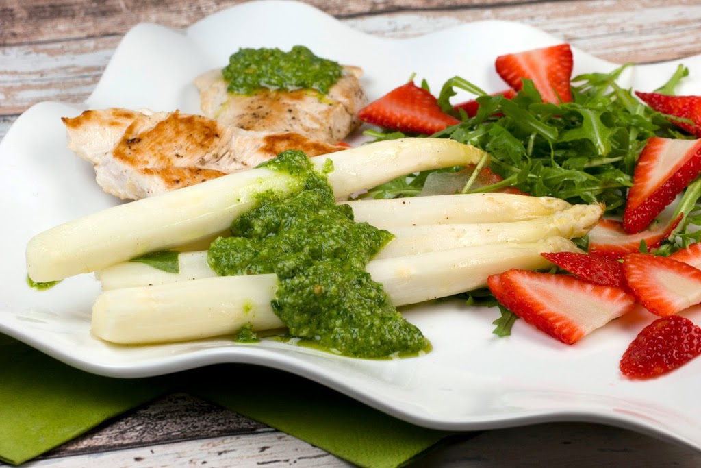 Asparagus in aluminum foil cooked with turkey fillets and basil rocket pesto